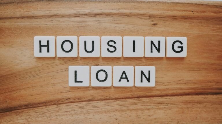木质桌面上用白色字母方块拼出"HOUSING LOAN"字样
